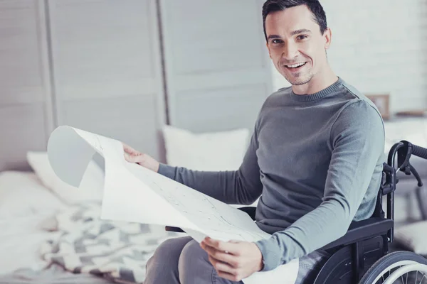 Positive cheerful man holding a blueprint — Stock Photo, Image