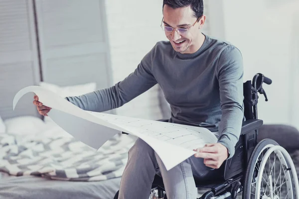 Smart handicapped man studying the drawing — Stock Photo, Image