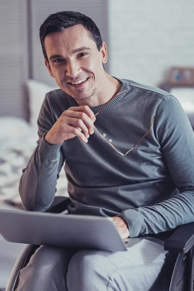 Positivo alegre homem segurando seus óculos — Fotografia de Stock