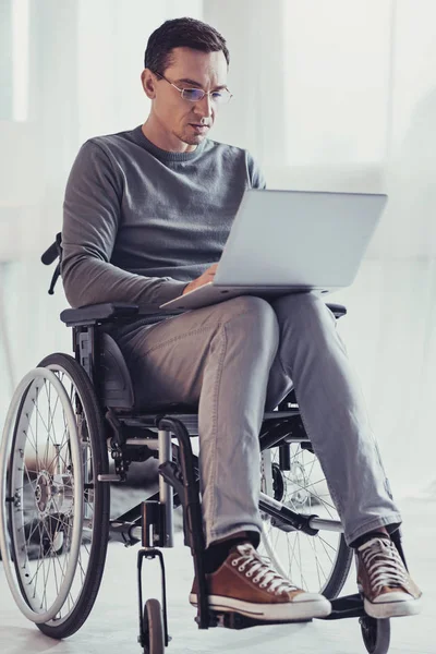 Serious handicapped man focusing on work