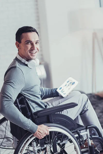 Delighted handsome man sitting in the wheelchair — Stock Photo, Image