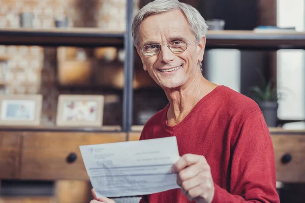Duygusal emekli yeni faturaları aldıktan sonra gülümseyerek — Stok fotoğraf