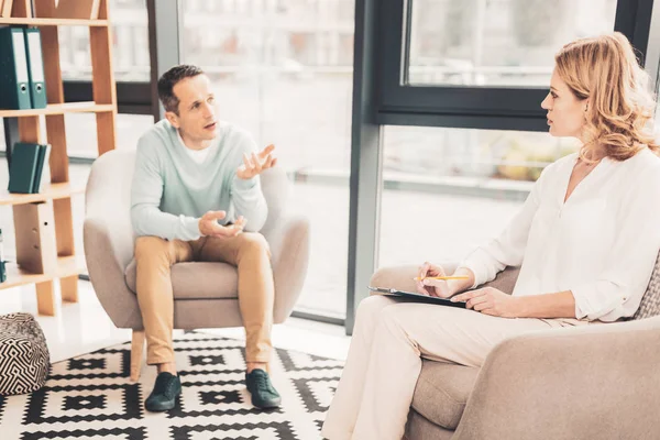 Oroliga mannen förklarar hans problem till psykoterapeut — Stockfoto