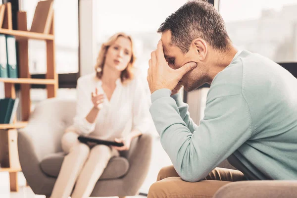 Стресована людина відчуває тривогу, розмовляючи з терапевтом — стокове фото