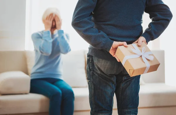 Attente oudere man presenteert zijn liefhebbende vrouw met cadeau — Stockfoto