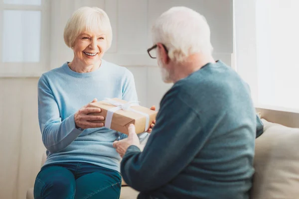 Mujer bonita sonriendo mientras recibe regalo maravilloso — Foto de Stock