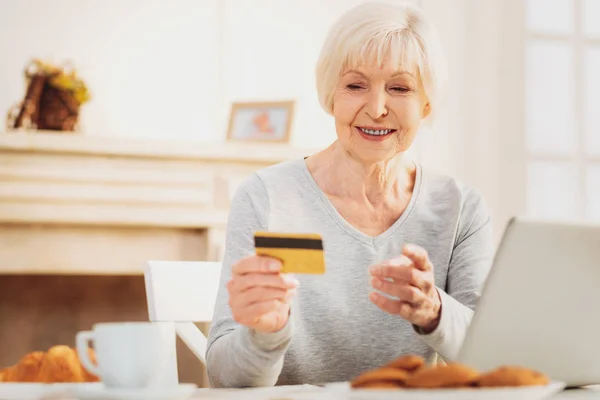 Aged woman holding her discount card preparing for shopping — Stock Photo, Image
