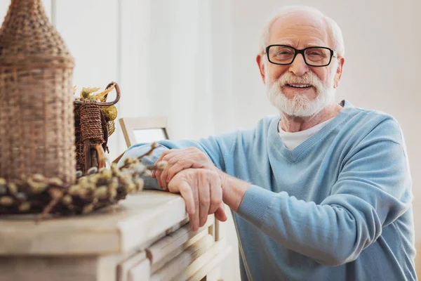 Bărbat fericit în vârstă în picioare lângă șemineu acasă — Fotografie, imagine de stoc