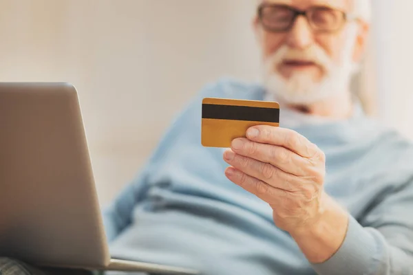 Busy aged man holding debit card in his hand