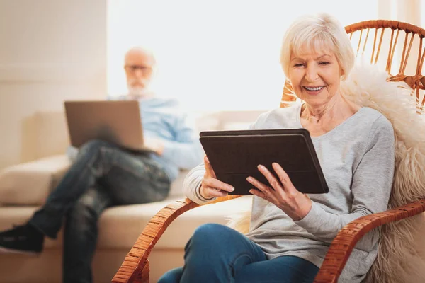 Pensionista moderno riendo mientras ve la comedia en el ordenador portátil — Foto de Stock