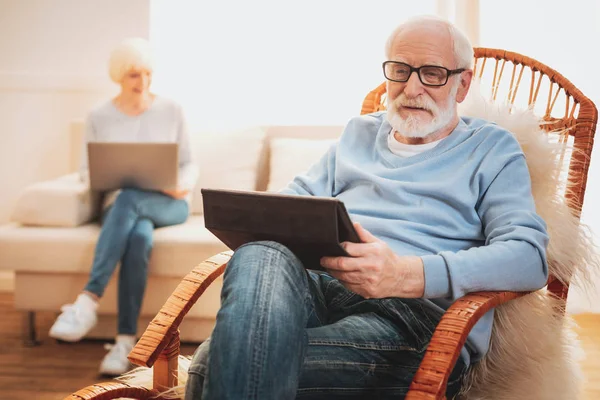 Умный пожилой человек читает политическую статью на ноутбуке — стоковое фото