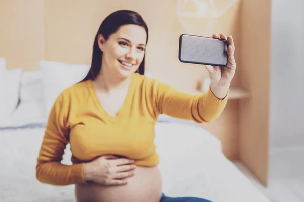Okouzlující budoucí matka pomocí svého smartphonu — Stock fotografie