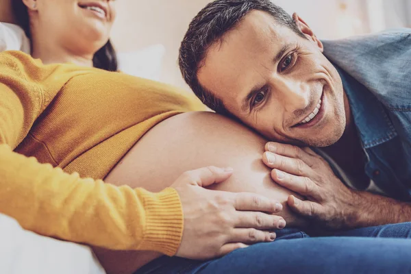 Futuro pai feliz inclinando a cabeça na barriga — Fotografia de Stock