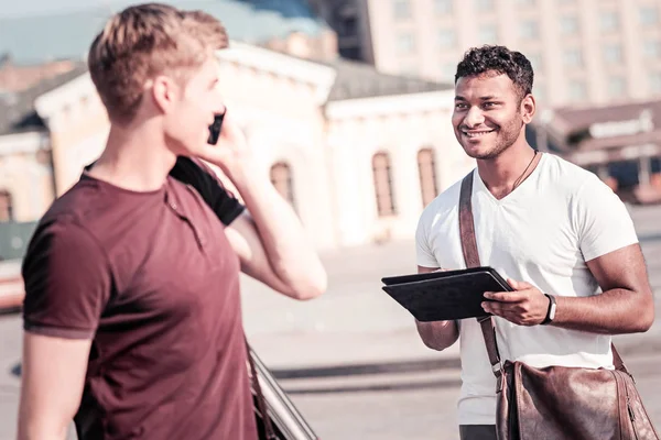 Entzückter junger Mann schaut seinen Mitschüler an — Stockfoto