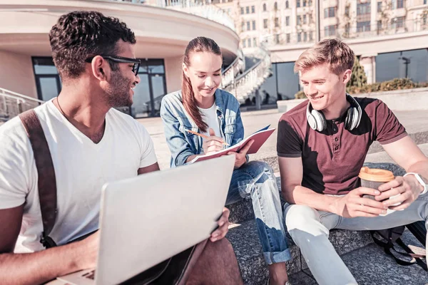 Hübsches Mädchen sitzt zwischen ihren Gruppenkameraden — Stockfoto