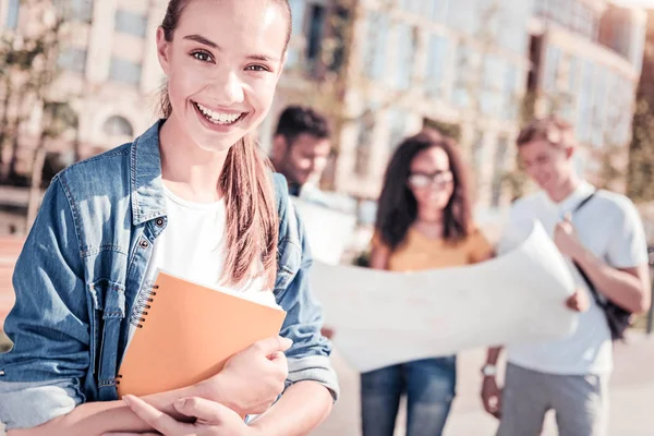 Atractiva morena abrazando su cuaderno — Foto de Stock