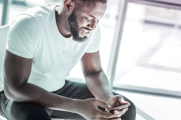 Alegre persona masculina internacional utilizando su gadget — Foto de Stock