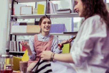 Tartışma sırasında ellerini yayılan ışık saçlı kız gülümseyerek