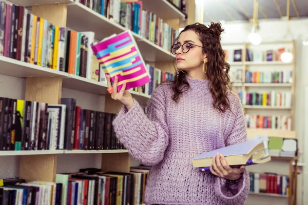 Chica grave concentrado llevando libro abierto en la mano levantada —  Fotos de Stock