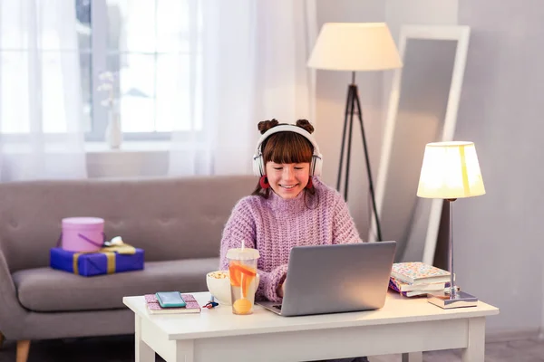 Positivo encantado adolescente usando seu laptop durante o estudo — Fotografia de Stock