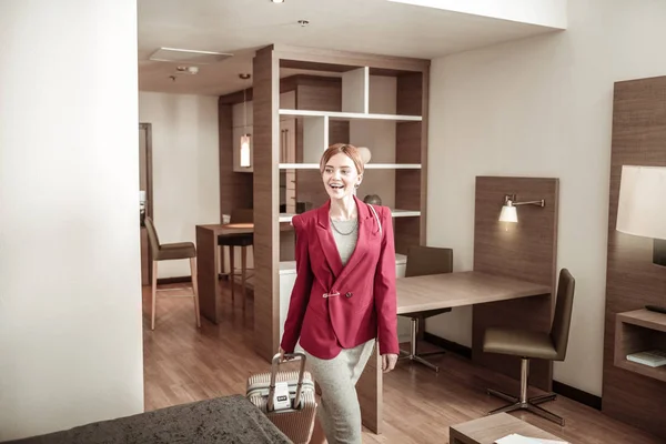 Блондинка носить багаж під час входу в готельний номер — стокове фото