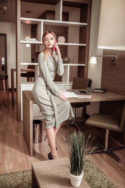 Επιχειρηματίας φορώντας μακρύ γκρί φόρεμα καλώντας τον συνάδελφό της — Φωτογραφία Αρχείου