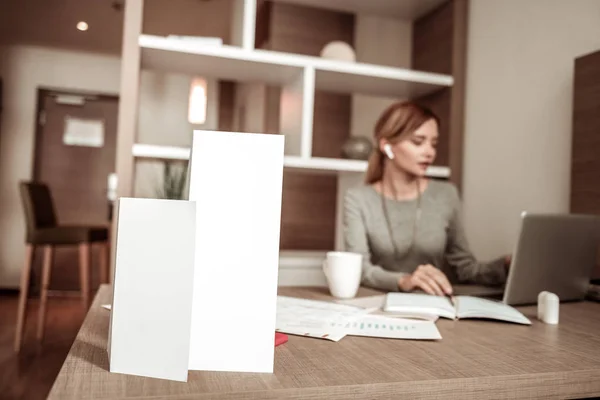 Fleißige Frau sitzt mit Dokumenten am Tisch — Stockfoto