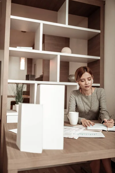 Geschäftsfrau macht sich nach Arbeitstag Notizen im Planer — Stockfoto