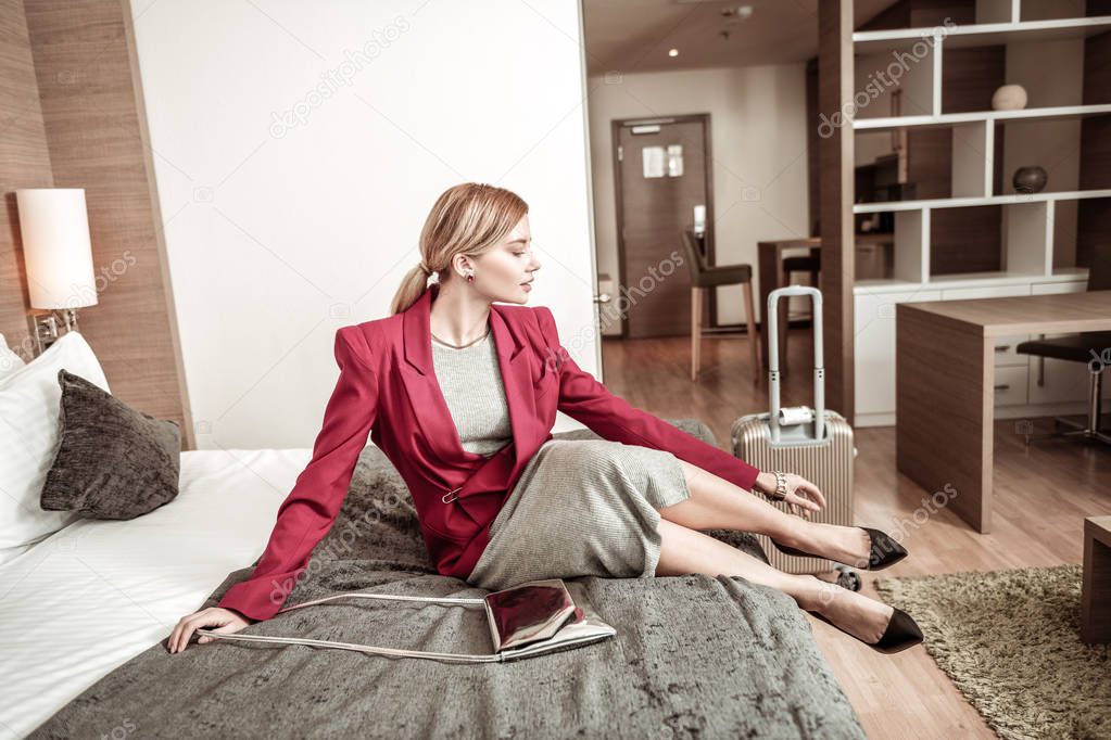 Tired stylish businesswoman taking her shoes off after flight