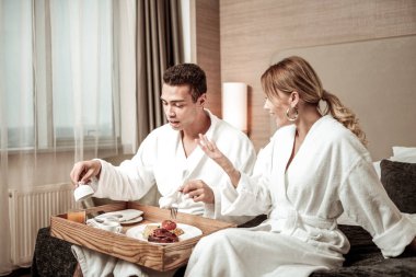 Sarışın karısı kocasıyla konuşmak beyaz bornoz giyiyor