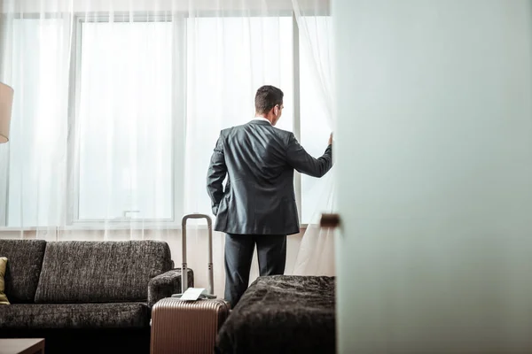 Podnikatel, kontrola výhledem ze svého hotelového pokoje — Stock fotografie