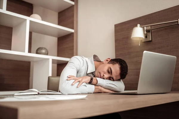 Busy exhausted businessman falling asleep on his working table