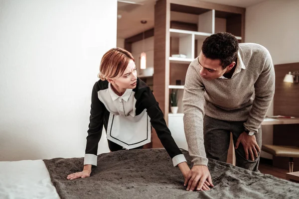 Blonde housekeeper feeling scared while client flirting with her — Stock Photo, Image