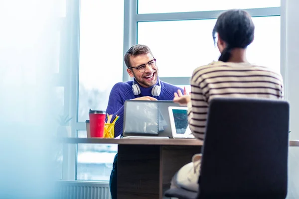 Vrolijke jongeman met aangename praten met collega — Stockfoto