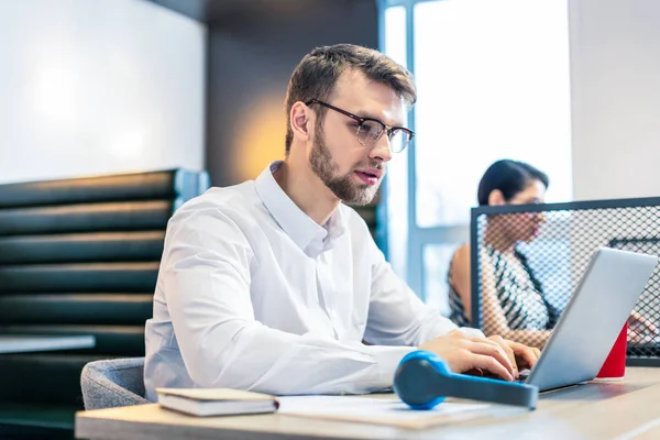 Ernstige jonge kantoormedewerker staren naar het scherm van de computer — Stockfoto