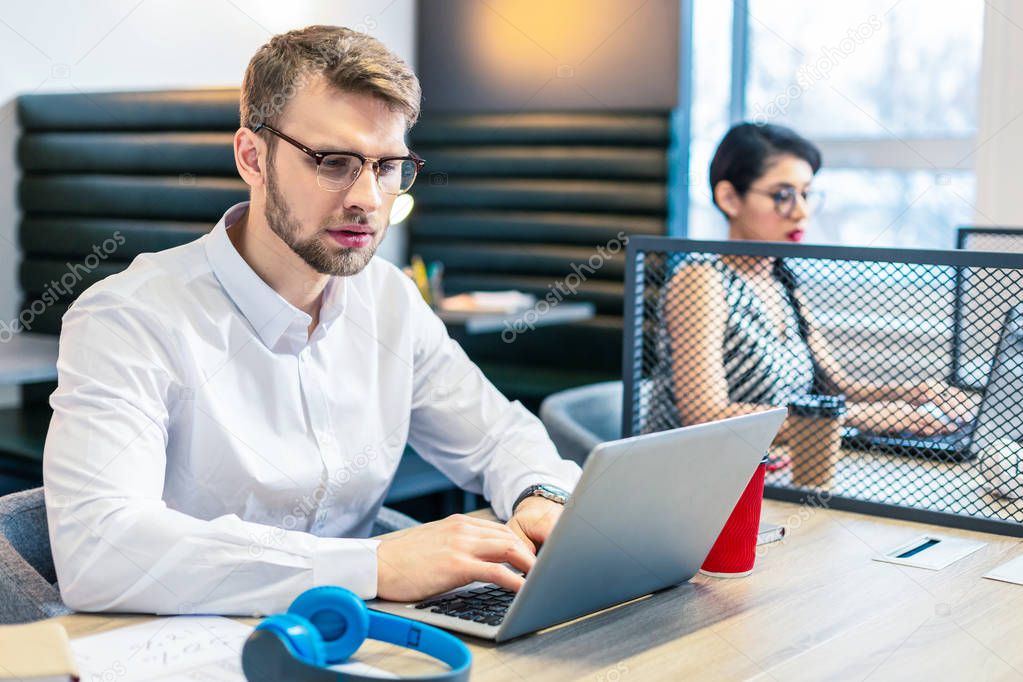 Serious bearded man staring at screen of computer