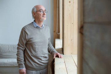 Dalgın üst düzey adam pencereden bakan