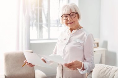Yaşlı kadın eğitim belgeleri araştırma sonuçları ile gülümseyen
