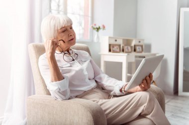 Sevimli yaşlı kadınla tablet dikkatle okuma