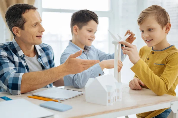 Upbeat boys scrutinizing wind turbine models in fathers office — Stock Photo, Image