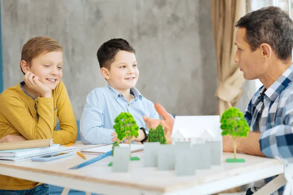 Joven arquitecto explicando a sus hijos sobre su trabajo — Foto de Stock