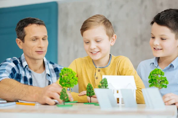 Agradable padre ayudando a sus hijos con el proyecto de ecología — Foto de Stock