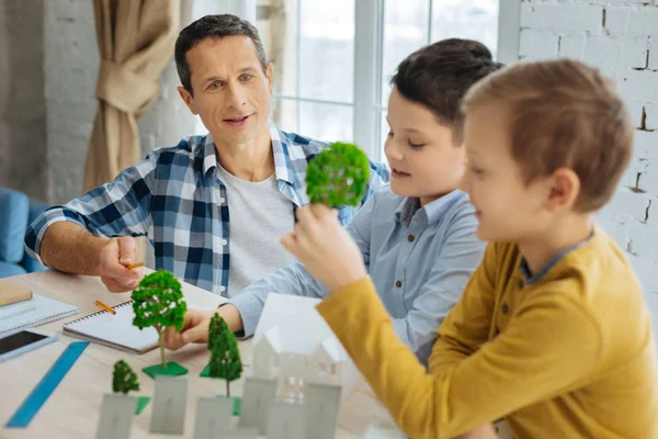 Joven ingeniero contando a sus hijos sobre arquitectura paisajística — Foto de Stock