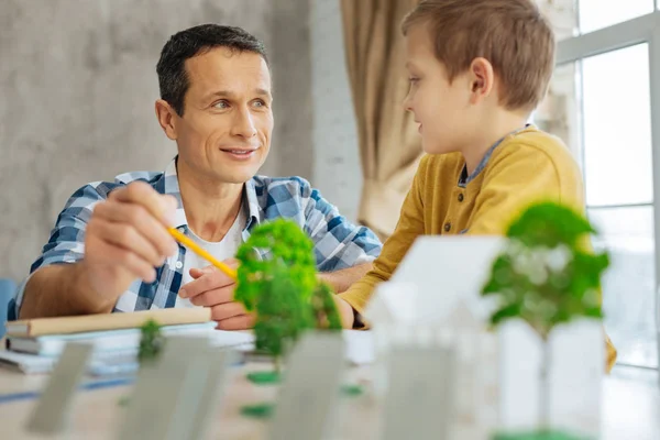 Hijo cariñoso interesado en el proyecto de arquitecto de sus padres — Foto de Stock