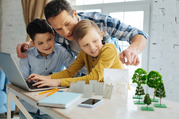 Liefdevolle vader zijn zonen helpen met hun project ecologie — Stockfoto