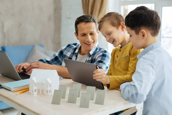 Adorables chicos mostrando vídeo en la tableta a su padre —  Fotos de Stock