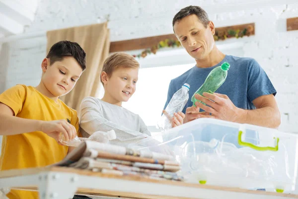 Vater und Söhne bereiten Plastikflaschen für das Recycling vor — Stockfoto