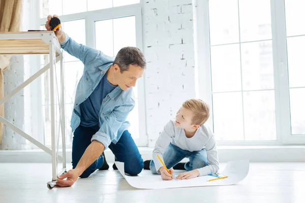 Cheerful father and son creating blueprint of a table — Stock Photo, Image