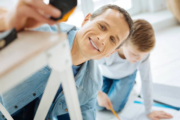 Close up of young man measuring the table leg — Stock Photo, Image