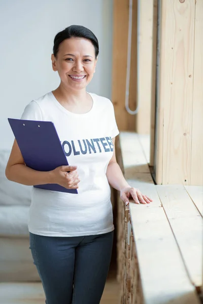 Optimistic female volunteer serving people